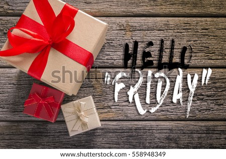 Gift boxes on rustic wooden table with word Hello Friday.