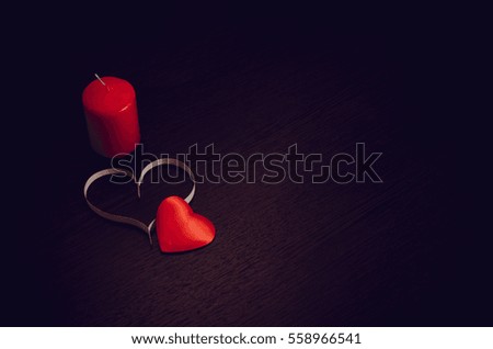 Candle and heart for Valentine's day. Dark texture with romantic symbol of love.