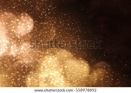 Golden abstract sparkles or glitter lights. Festive gold background.defocused circles bokeh or particles. Valentines day template Royalty-Free Stock Photo #558978892