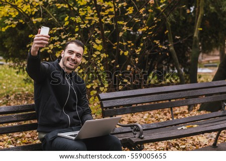 Man taking a selfie and smiling while working in the park