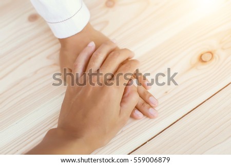 Closeup of loving couple holding hands while walking at sunset 