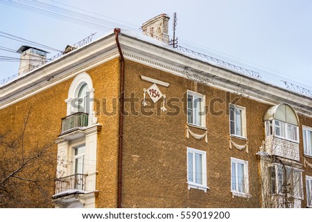 Red residential house in a residential area. Walking area. Winter landscape. Open space. Contemporary Russia. 