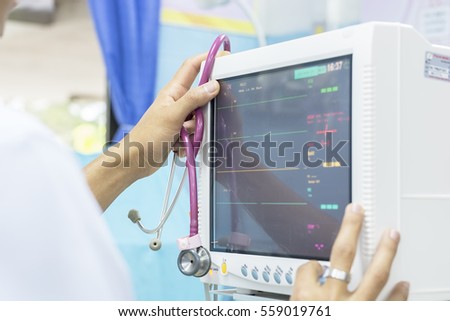 Men holding a stethoscope and using electrocardiogram in the emergency room of the hospital.
