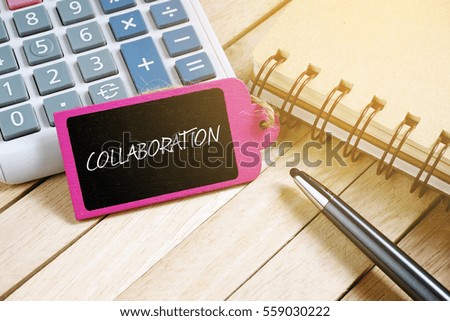 Notebook, pen, calculator and wooden tag written with COLLABORATION on wooden background. Business Concept.