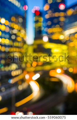 Blurred night architecture skyscrapers with glass facade. Modern buildings in Paris business district. Evening dynamic traffic on a street. Concept of economics, financial.  Copy space for text. Toned