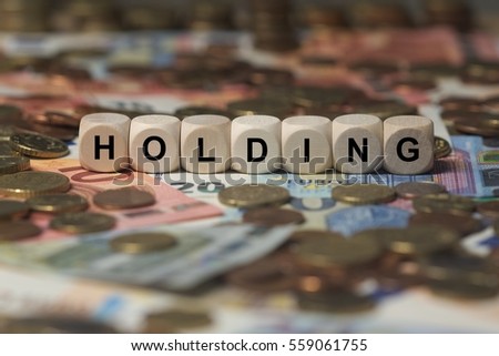 holding - cube with letters, money sector terms - sign with wooden cubes