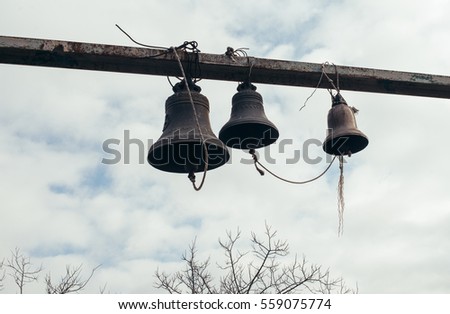 Traditional old bells hanging on beam near georgian orthodox temple, concept of religion, faith and peace