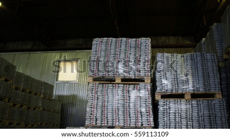 Pallets with metal bricks are in big storage of melting shop manufacture.