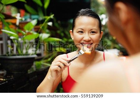 Woman eating, facing another person