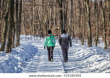 Two girl friends walking in the forest