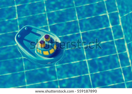 Rubber toy blue ship floats in the pool