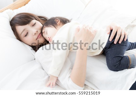 portrait of asian mother and baby on tthe bed