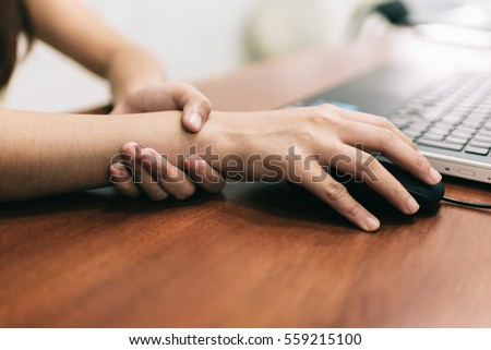 Woman holding her wrist pain from using computer. Office syndrome  Royalty-Free Stock Photo #559215100