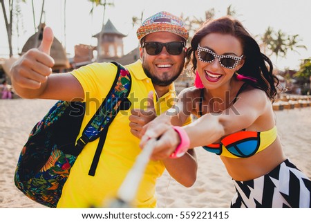young beautiful hipster couple in love on tropical beach, taking selfie photo, sunglasses, stylish outfit, summer vacation, having fun, smiling, happy, colorful, positive emotion