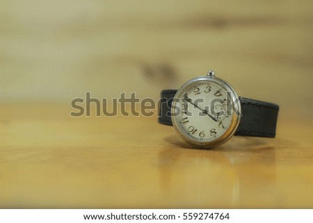 watch on wooden table.selective focus.vintage tone