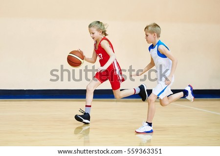 Girl and boy athlete in sport uniform playing basketball