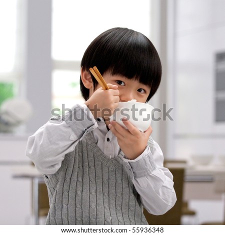 Asian boy eating rice with chopsticks Royalty-Free Stock Photo #55936348
