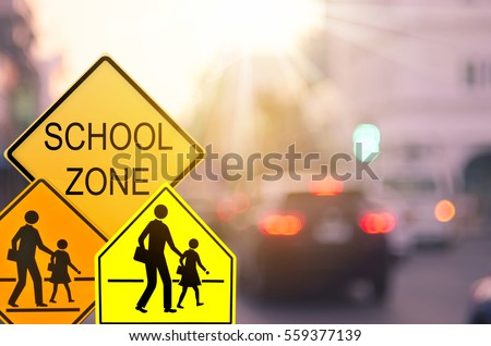 Set of School zone warning sign on blur traffic road with colorful bokeh light abstract background. Copy space of transportation and travel concept. Vintage tone filter effect color style.  