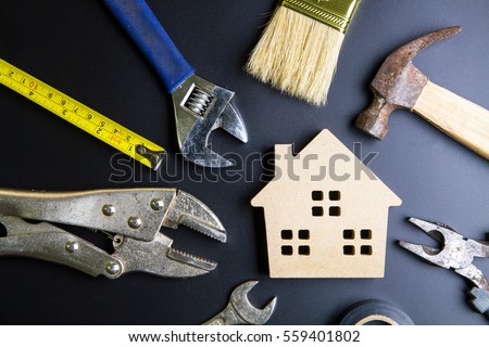 Wooden house toy and construction tools on black background with copy space.Real estate concept, New house concept, Finance loan business concept, Repair maintenance concept Royalty-Free Stock Photo #559401802