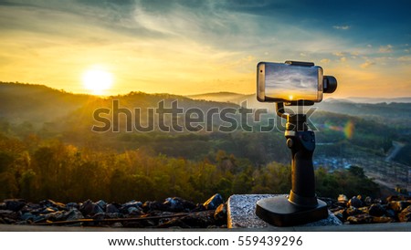 Close-up Smartphone take a Mountians Landscape photo and video timelapse on stand  Mobile Stabilizer in sunset
