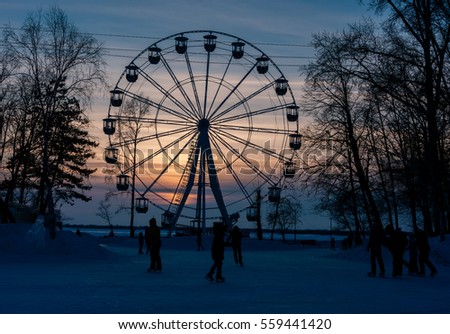 The Ferris wheel on the banks of the Amur River at sunset