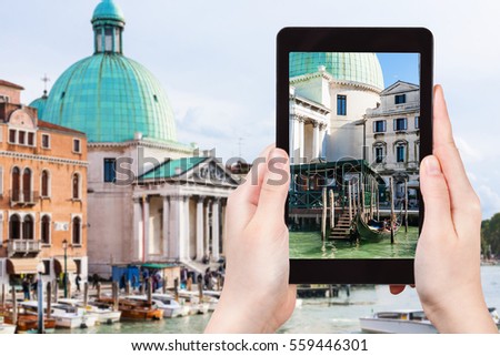 travel concept - tourist photographs Church San Simeone Piccolo in Venice city on tablet in Italy