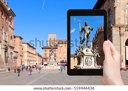 travel concept - tourist photographs fountain of Neptune in Bologna city on tablet in Italy