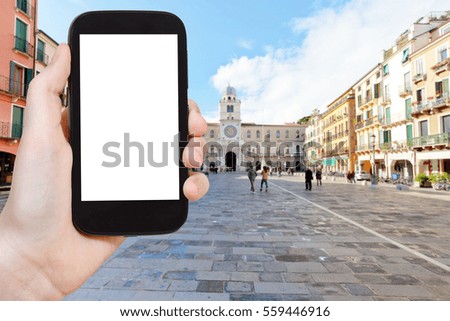 travel concept - tourist photographs piazza dei Signori in Padua city on smartphone with cut out screen with blank place for advertising in Italy