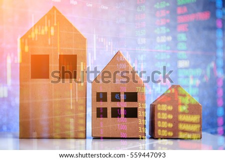 house in brown recycled paper on white floor and blur bokeh with stock market trade graphic.jpg