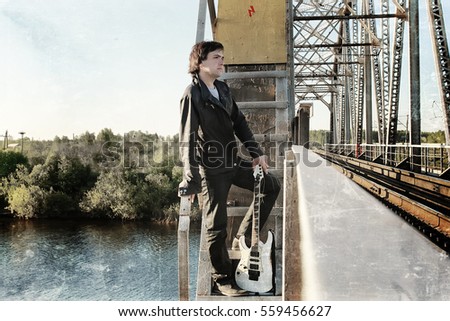 scratch effect on photo men with guitar on a railroad