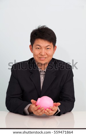 Businessman with pink piggy bank and coin