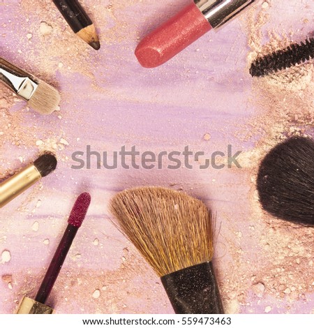 Makeup brushes, lipstick and pencil on a light purple background, with traces of powder and blush on it. A square template for a makeup artist's business card or flyer design, with copyspace