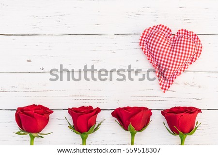 Romantic red fabric heart and fresh red roses blossoms on white wood, love background for Valentines Day, Anniversary, Birthday, Mothers Day or Womans Day.