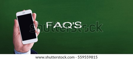 Smart phone in hand front of blackboard and written FAQ'S