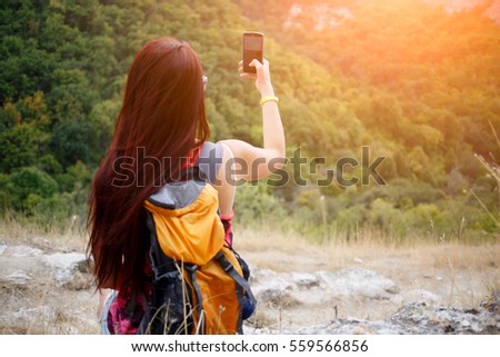 Girl with backpack near mountain