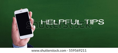 Smart phone in hand front of blackboard and written HELPFUL TIPS