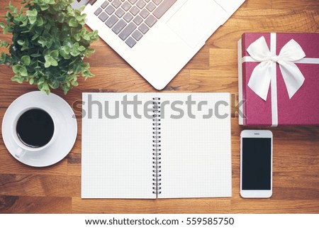Coffee cup and notebook smartphone on wooden table background 