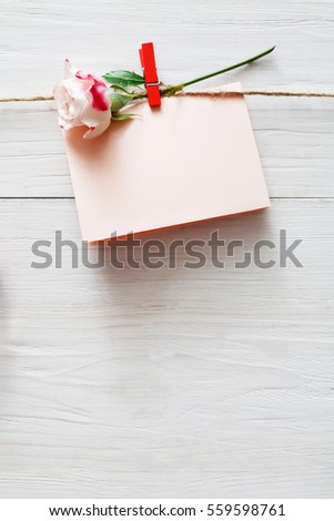 Valentine background, empty greeting card on clothespin on white rustic wood planks. Happy lovers day card mockup, copy space