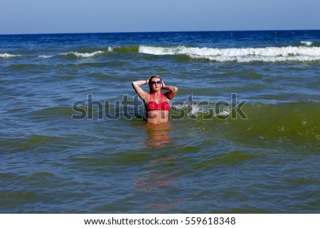 the beautiful woman bathes in sea waves
