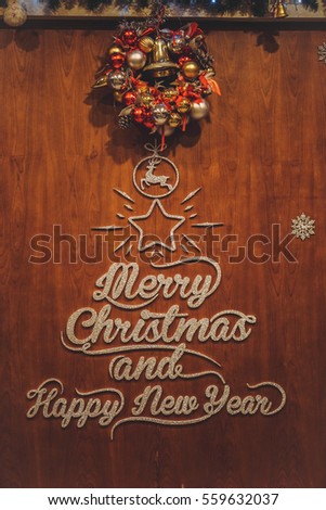 Merry Christmas and Happy New Year typography decoration on the wooden board | Warm december holiday style pine tree decorate with bells and deer