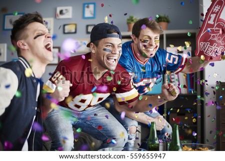 American football fans among falling confetti Royalty-Free Stock Photo #559655947