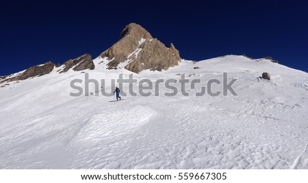 Mountaineering skier while climbing on the hill, panoramic view of snowy mountain peak with perspective from the bottom to the top, Pic d'Asti, Alps, Italy