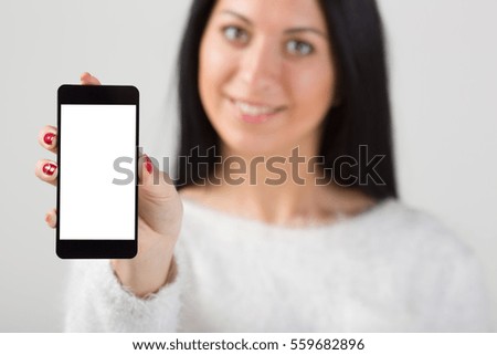 Businesswoman holding smartphone in hand. Gray background