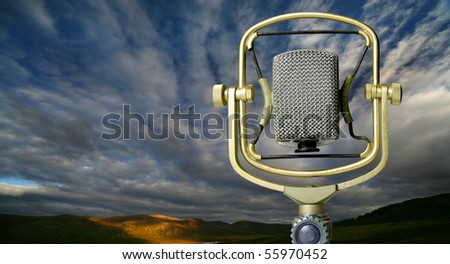 Old microphone against autumn wood