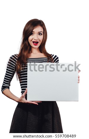 Long-haired beautiful cute brunette woman holding a rectangular blank-poster white canvas with space for text. White background, isolated, studio. Red lips. Surprise, open mouth, low prices