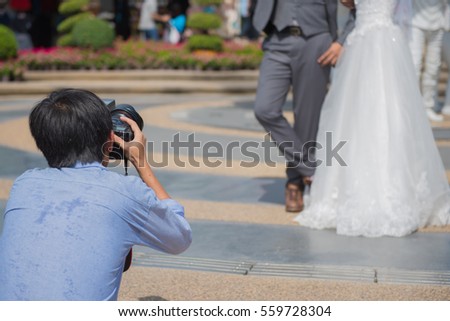 wedding photographer takes pictures of the bride and groom in park, the photographer in action.