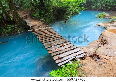 Rio celeste and small wooden bridge Tenorio national park Costa Rica Royalty-Free Stock Photo #559729903