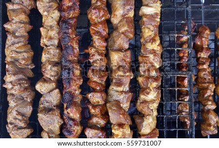 Shashlik roasting on hot grill, one piece scorched.