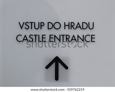 a sign that said entrance to the castle in two languages English and Czech, black letters on a clear background