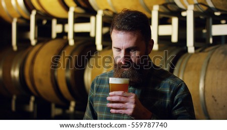 
expert brewer of beer tastes in style hipster uan clear double malt beer. concept of craft beer and plenty of hops. Royalty-Free Stock Photo #559787740